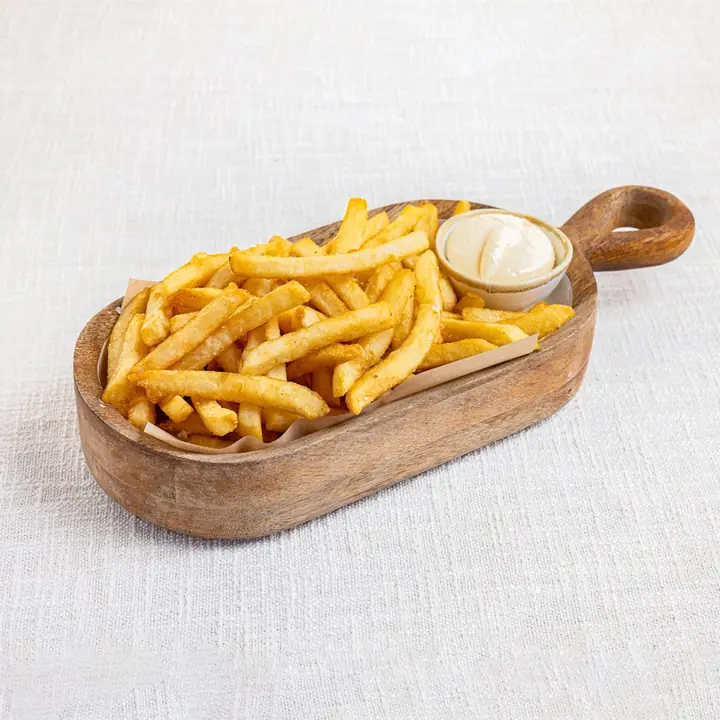 Golden chips with aioli served on a wooden board