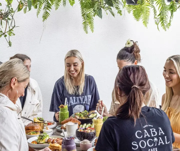 Guests laughing over brunch at a shared table