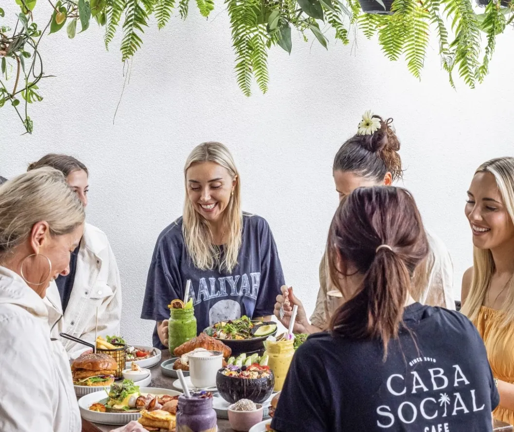 Guests passing plates around a shared brunch table at Caba Social
