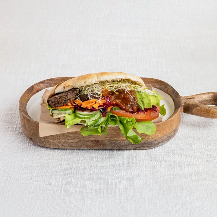 Harvest pita filled with fresh salad, served on a wooden board