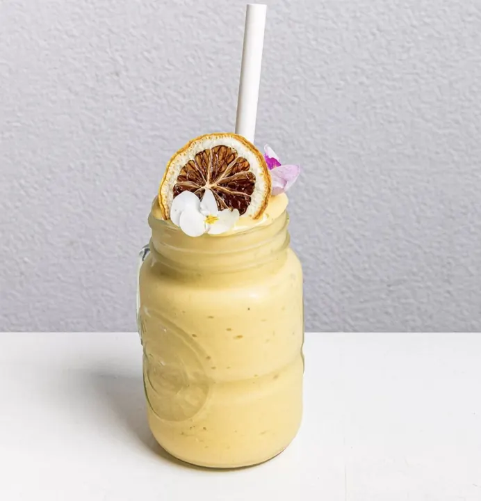 Californian Dreamin smoothie in a mason jar with a paper straw and dried orange garnish