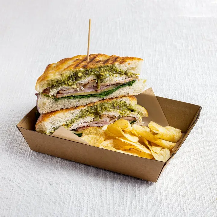 Chicken, bacon and pesto toastie with crisps in a kraft tray