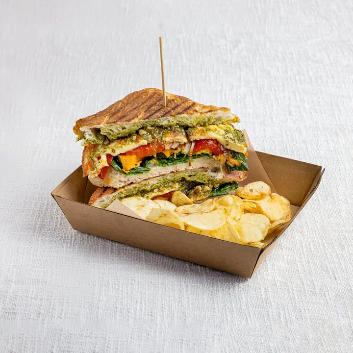 Roast veg and halloumi toastie with crisps in a kraft tray